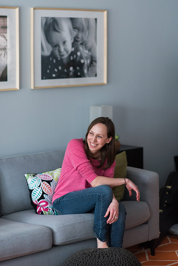 Photographer and Photo Educator, Allie Siarto, sits at home in front of framed prints